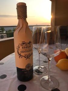 a bottle of wine and two glasses on a table at Apartment Heaven Hill in Jadranovo
