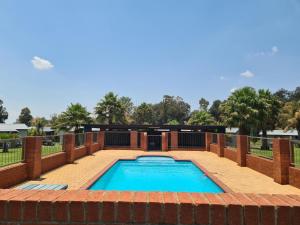 una piscina con patio in mattoni e piscina con piscina di Snips Accommodation a Newcastle
