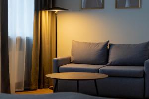 a living room with a blue couch and a table at Narva Hotell & Spaa in Narva