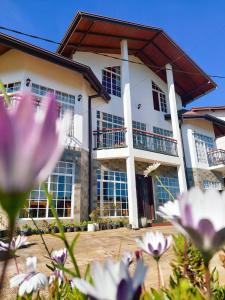 ein Gebäude mit Blumen davor in der Unterkunft Misthill Rest - Lavish Villa in Nuwara Eliya