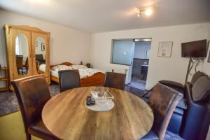 Pokój z drewnianym stołem, krzesłami i łóżkiem w obiekcie Appartement Haus Schröder w mieście Söll
