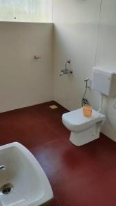 La salle de bains est pourvue de toilettes blanches et d'un lavabo. dans l'établissement The Tribe Agrotourism, Wai mahabaleshwar, à Panchgani