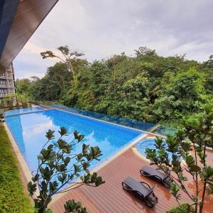 a swimming pool with chairs on a wooden deck at The Glass Homestay Putrajaya in Putrajaya