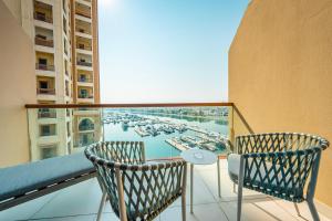 un balcone con 2 sedie, un tavolo e una finestra di Ain Dubai and sunset view studio a Dubai