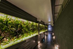 een lege hal met een overdekte plantenmuur bij Hotel Ritmo & Gessy ラブホテル in Fukuoka