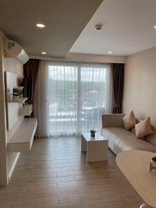 ein Wohnzimmer mit Couch und großem Fenster in der Unterkunft SEVEN SEAS CONDO RESORT in Jomtien Beach