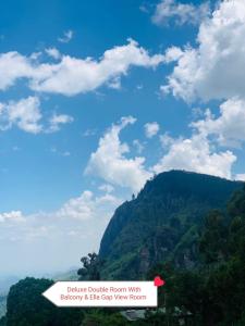 een uitzicht op een berg met een blauwe lucht en wolken bij The Rock Face in Ella