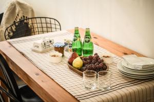 a table with two bottles and a tray of fruit at Cozy Modern 1BR Duplex Apt w Balcony Near City Center by Sea N' Rent in Tel Aviv