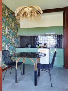 a kitchen with a table and two chairs and a chandelier at Kaz C2C - Une maison Balinaise avec jacuzzi in Saint-Pierre