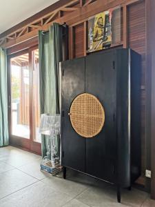ein schwarzer Schrank mit kreisförmiger Tür in einem Zimmer in der Unterkunft Kaz C2C - Une maison Balinaise avec jacuzzi in Saint-Pierre