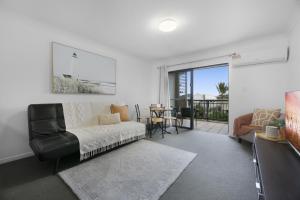 a living room with a couch and a table at 'Little Mermaid' beach apartment best location walk to beach and restaurants - sleeps 4 in Gold Coast