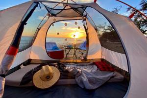 - une tente sur la plage avec un chapeau dans l'établissement Epic Maui Car Camping, à Kahului