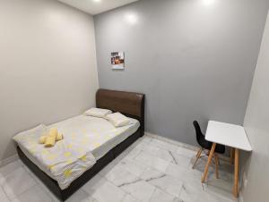 a small bedroom with a bed and a desk at AK Homestay in Port Dickson