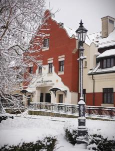 una luz de la calle en la nieve frente a un edificio en Grand Sal en Wieliczka