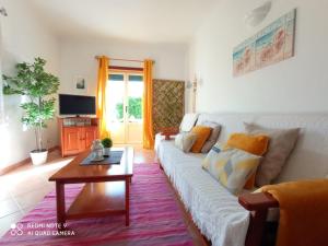 un soggiorno con divano bianco e tavolo di Sun & Surf Flat Arrifana Beach ad Aljezur