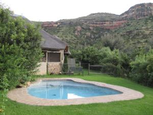 una piscina en un patio con una casa en Mafube Mountain Retreat, en Fouriesburg
