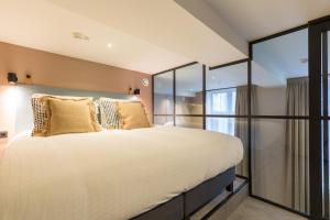 a bedroom with a large bed and large windows at Ocean House Scheveningen in Scheveningen