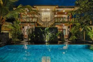 a villa with a swimming pool at night at Kubu Rama Ubud Cottage in Ubud