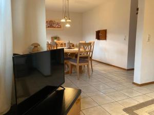 a living room with a television and a dining room at Comfortable holiday home Manderscheid with garden in Manderscheid