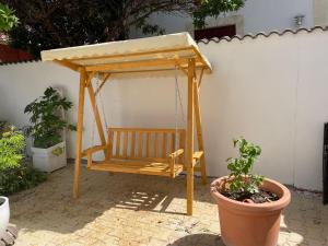 a wooden swing with a canopy in a garden at 3 pieces avec terrasse entre plage et centre ville in Arcachon
