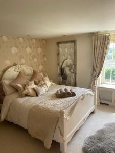 a bedroom with a white bed and a large mirror at Luxury Country Cottage in Smeeth