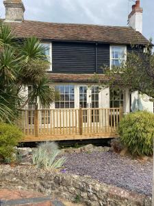 a house with a wooden deck in front of it at Luxury Country Cottage in Smeeth