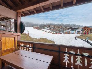 a view of a ski slope from a balcony with a table at Appartement cosy au pied des pistes avec mezzanine, poêle à bois et services inclus pour 4 personnes - FR-1-570-28 in Saint-Martin-de-Belleville