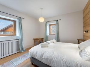 ein Schlafzimmer mit einem großen weißen Bett und einem Fenster in der Unterkunft Chalet familial neuf avec sauna et spa, proche des pistes, accueille 12 personnes et animaux admis - FR-1-570-30 in Praranger