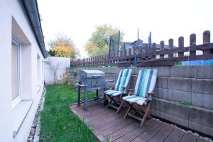 two chairs sitting on a deck next to a grill at T&K Apartments - Dusseldorf - 2 rooms - Ground floor in Düsseldorf