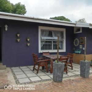 a patio with a table and chairs in front of a house at The Marilyn Room in Centurion