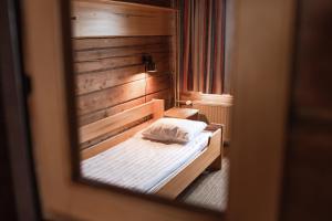 Lapland Hotels Pallas في بالّاستونتوري: غرفة نوم بسرير مع جدار خشبي