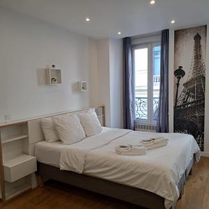 a bedroom with a bed with two towels on it at Maison le Bac Paris Aparthotel in Paris