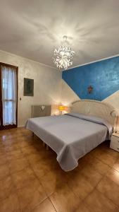 a bedroom with a large bed with a chandelier at Apartaments Marina del Cavallino in Cavallino-Treporti