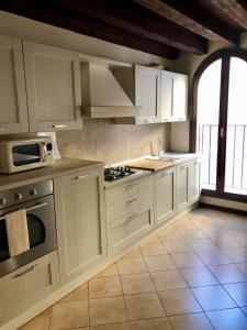 a kitchen with white cabinets and a large window at Palazzo Bianchetti in Treviso