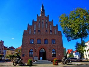 a red brick building with a tower on top at Hytte Narie 2 in Bogaczewo +5 photos