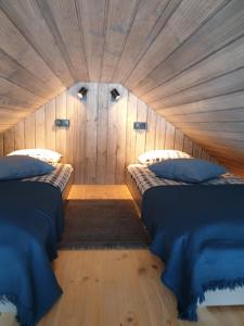 a bedroom with two beds in a wooden room at Hytte Narie 2 in Bogaczewo