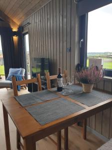 a wooden table with a bottle of wine and glasses at Hytte Narie 2 in Bogaczewo