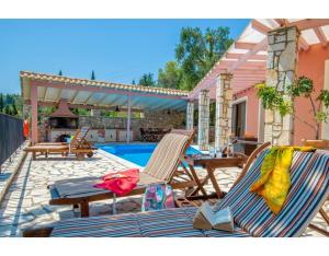um pátio com 2 espreguiçadeiras e uma piscina em Villa Faye em Gaios