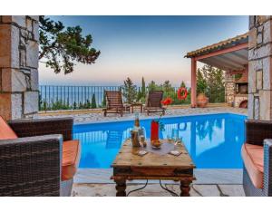 una piscina con mesa y sillas junto a una piscina en Villa Faye en Gaios