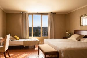 una camera d'albergo con due letti e una finestra di Bremon Boutique Hotel by Duquessa Hotel Collection a Cardona
