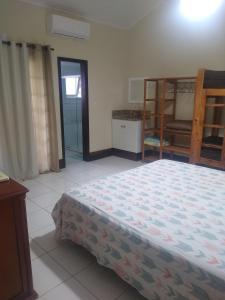 a bedroom with a bed and a room with a kitchen at Apartamento Condomínio Porto Bracuhy in Angra dos Reis