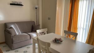 ein Wohnzimmer mit einem Tisch und einem Sofa in der Unterkunft Gatto Bianco le Dimore in Bari