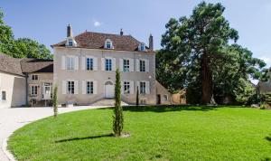 una gran casa blanca con árboles en el patio en Chambres d'hôtes Le Clos des Tilleuls, en Demigny