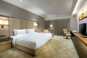 a hotel room with a bed and a television at CHECK inn Select Tainan Yongkang in Yongkang