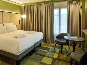 ル・テュケ・パリ・プラージュにあるMercure Hôtel Le Touquetのベッドとテーブルが備わるホテルルームです。