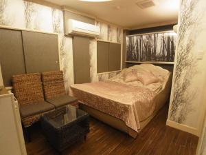 a small bedroom with a bed and a chair at SKYROAD Adult Only in Tokyo