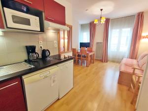 a kitchen and living room with a counter top at Oo, T2, centre Luchon, wifi, casier à skis, ascenseur, 4 personnes in Luchon +2 photos