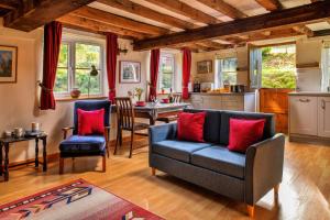 a living room with a blue couch and red pillows at Finest Retreats - Great Cantal Granary in Llandrindod Wells