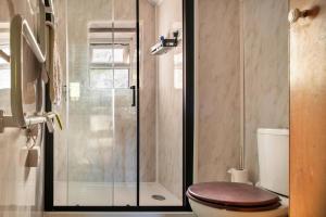 a bathroom with a toilet and a glass shower at Finest Retreats - Great Cantal Granary in Llandrindod Wells
