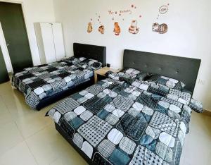 two beds sitting next to each other in a room at Cats' Kingdom SOHO-Dpulze Cyberjaya, Fit 5pax in Cyberjaya